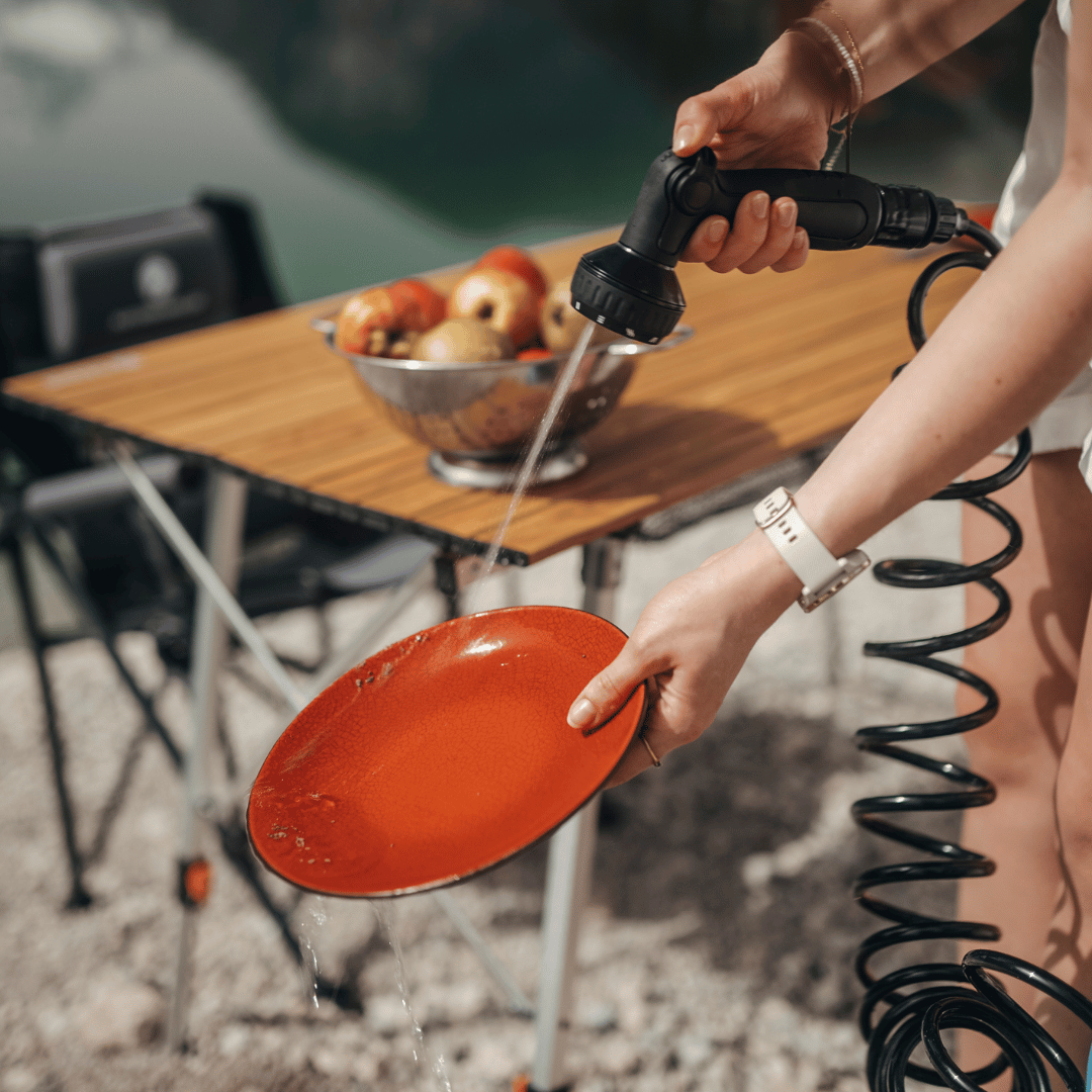 Beispielbild zur Verwendung einer Campingdusche beim Abwaschen von Campinggeschirr.  